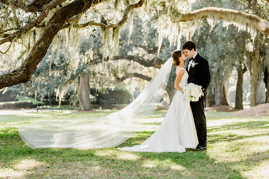 Bride and from under beautiful spanish moss oak trees