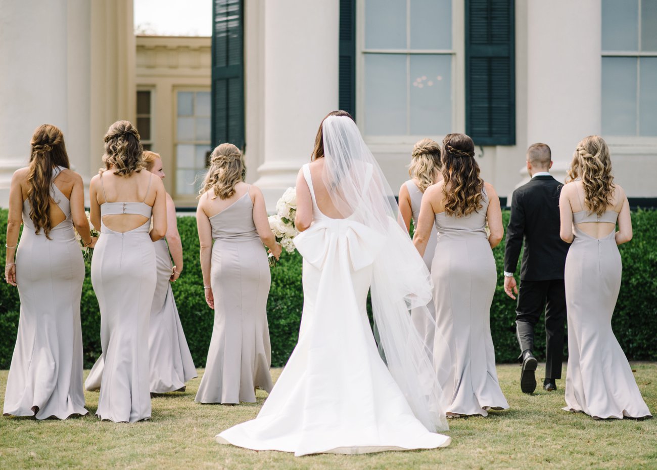 Bride and bridesmaids with large bow on her dress